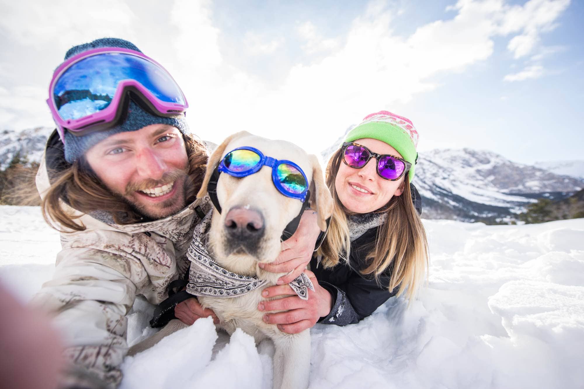 Couple playing with dog in the snow