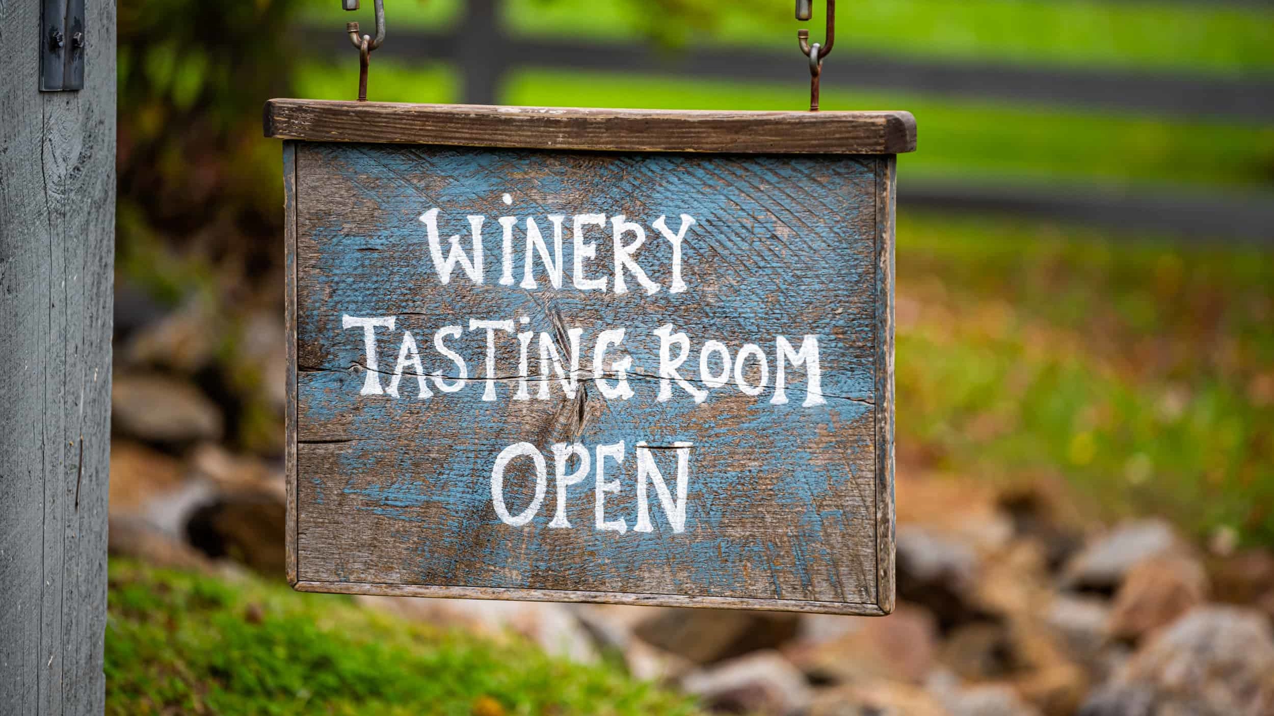 hanging sign that reads "winery tasting room open"