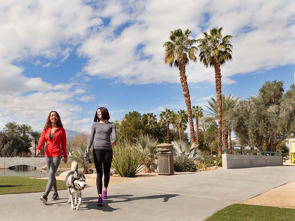 Two women walking a dog in Greater Palm Springs