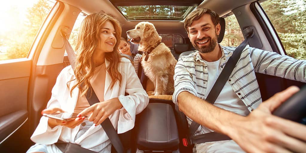 Mom,Dad,daughter-traveling-with-ipad-in-car-with-dog